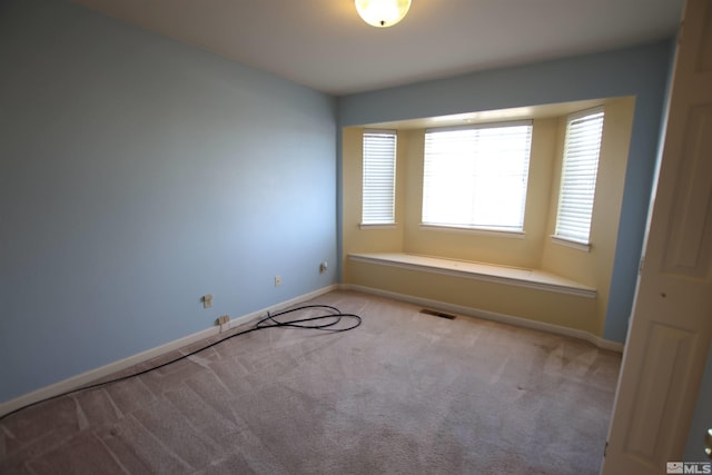 unfurnished room featuring light carpet