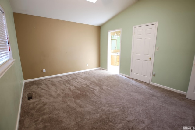 unfurnished room with carpet floors and lofted ceiling