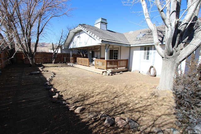 rear view of property featuring a wooden deck