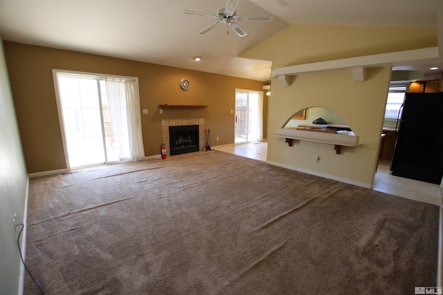 unfurnished living room featuring plenty of natural light, carpet, and vaulted ceiling