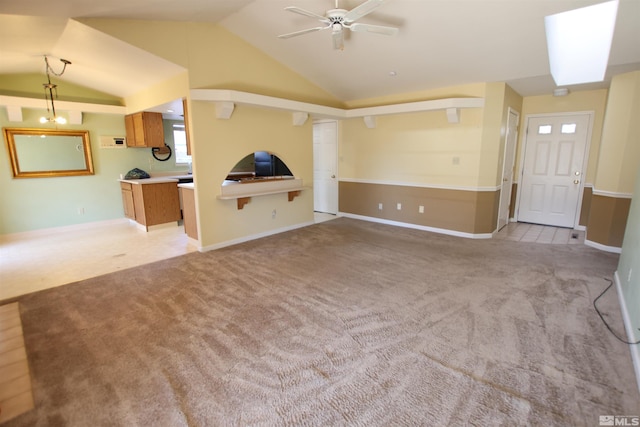 unfurnished living room featuring vaulted ceiling, ceiling fan, and light colored carpet