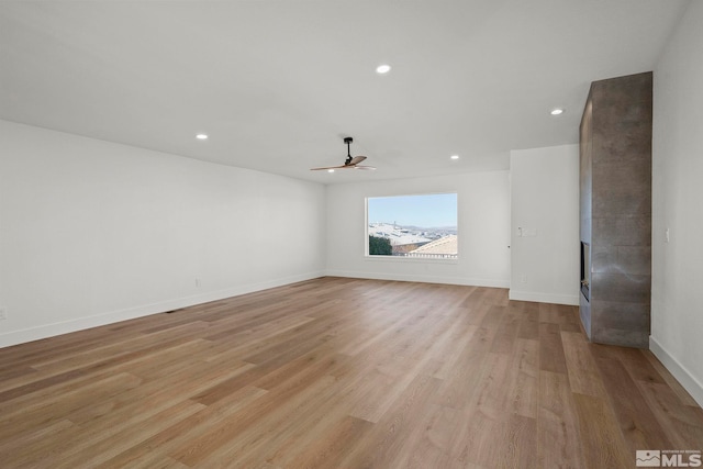 empty room with light wood-type flooring and ceiling fan