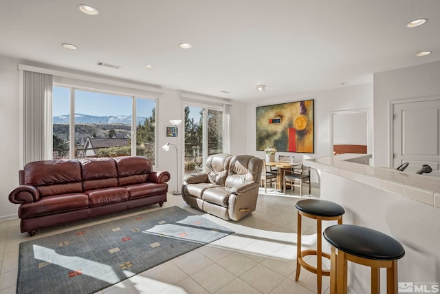 living room with a mountain view, a wealth of natural light, and light tile patterned floors