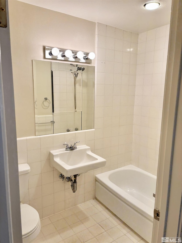 bathroom with sink, tile walls, tile patterned floors, and toilet