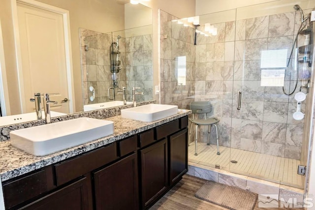 bathroom with hardwood / wood-style flooring, walk in shower, and vanity