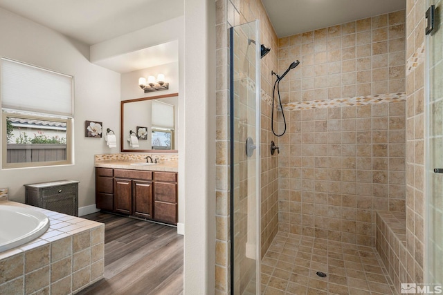 bathroom with hardwood / wood-style floors, vanity, and shower with separate bathtub