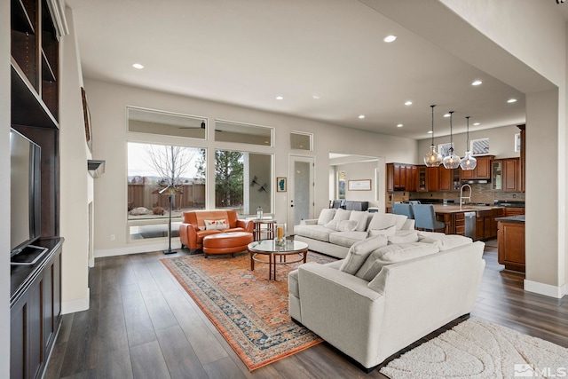 living room with sink, an inviting chandelier, and dark hardwood / wood-style floors