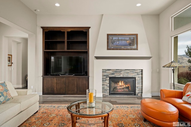 living room with a fireplace, hardwood / wood-style floors, and built in features