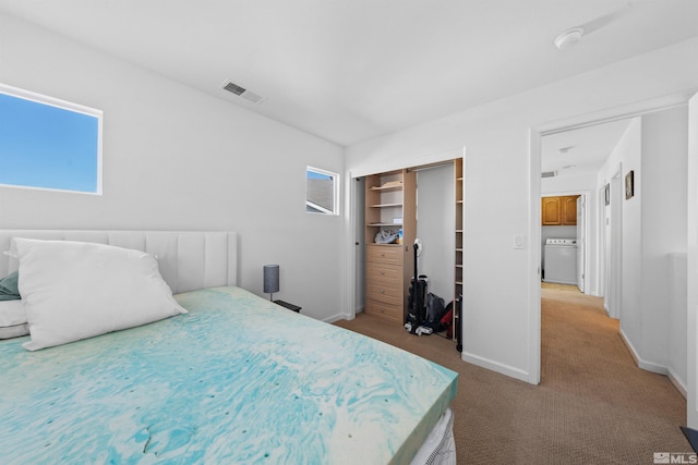 carpeted bedroom with a closet and washer / clothes dryer