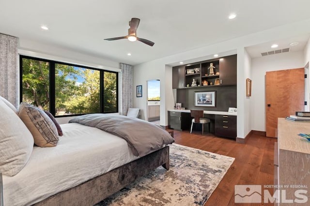 bedroom featuring built in desk, dark hardwood / wood-style floors, and ceiling fan