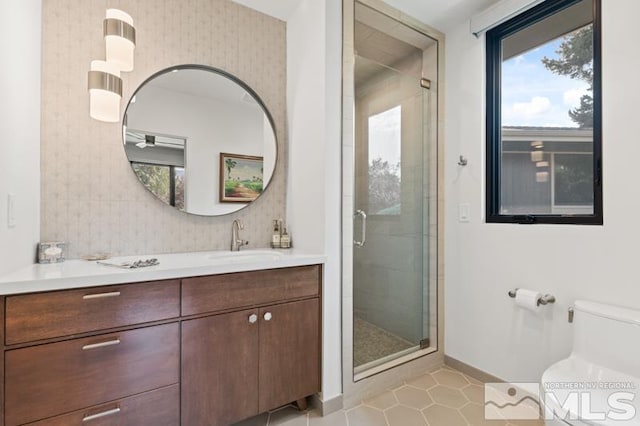 bathroom featuring walk in shower, vanity, toilet, and tile patterned flooring