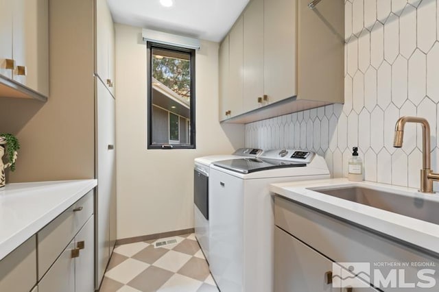 clothes washing area featuring cabinets, separate washer and dryer, and sink