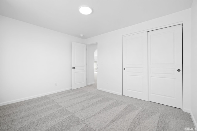 unfurnished bedroom featuring a closet and light carpet