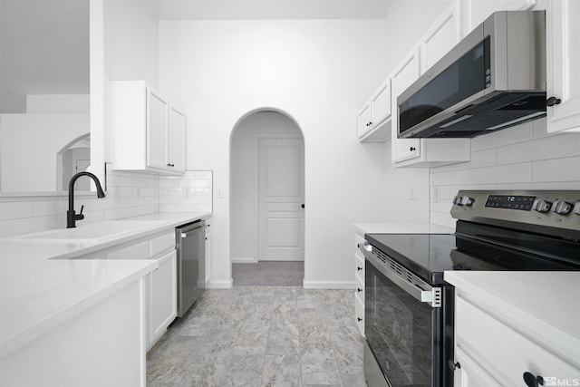 kitchen featuring sink, white cabinetry, appliances with stainless steel finishes, and tasteful backsplash