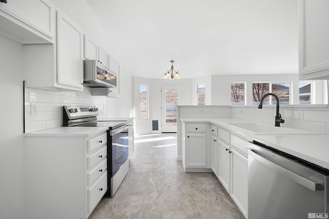 kitchen with sink, decorative light fixtures, tasteful backsplash, white cabinetry, and stainless steel appliances