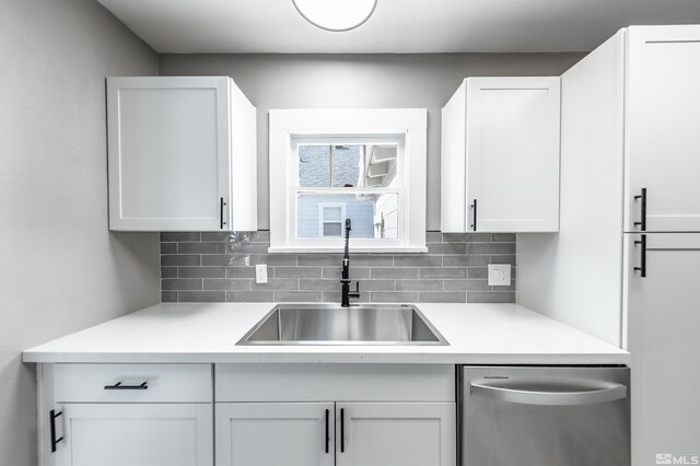 kitchen featuring white cabinets, tasteful backsplash, stainless steel dishwasher, and sink