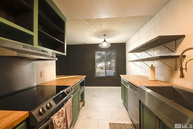 kitchen with decorative light fixtures, green cabinetry, and wooden counters