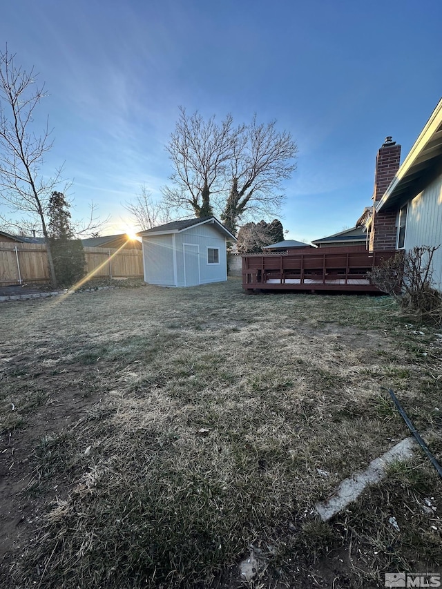 view of yard with a wooden deck and a storage unit