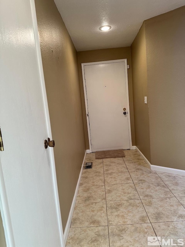 entryway featuring a textured ceiling and light tile patterned flooring