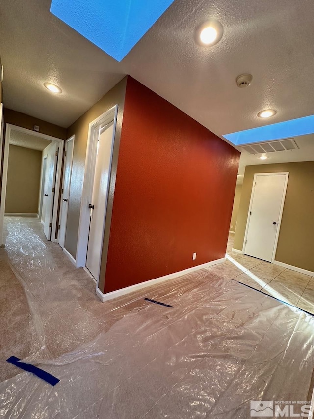 additional living space with a textured ceiling and a skylight