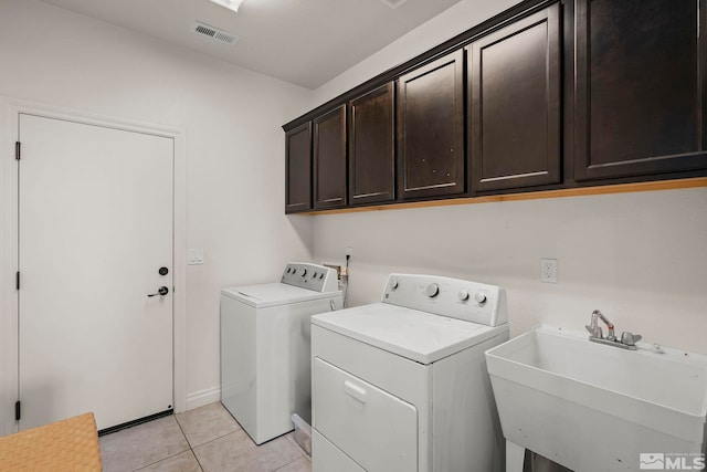 laundry area with sink, separate washer and dryer, cabinets, and light tile patterned floors