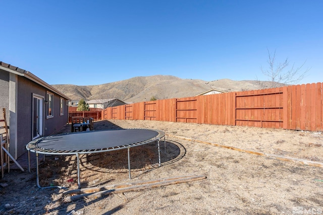 view of yard featuring a mountain view and a trampoline