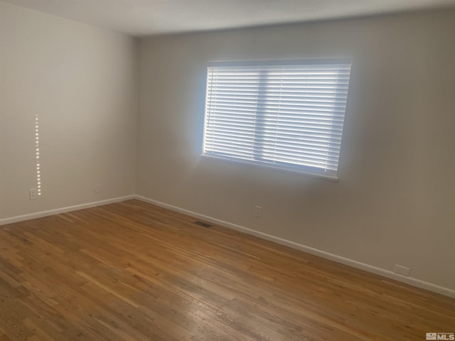 spare room with hardwood / wood-style floors