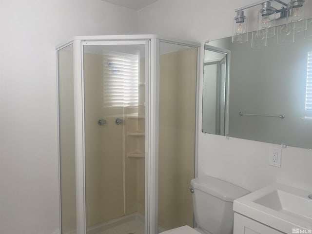 bathroom with vanity, a shower with shower door, and toilet