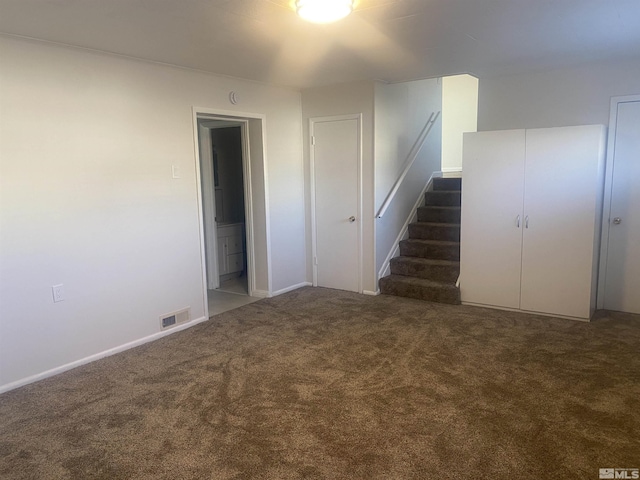 spare room with dark carpet