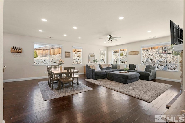 living room featuring plenty of natural light, ceiling fan, and dark hardwood / wood-style flooring