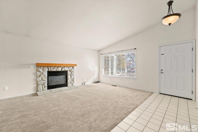 unfurnished living room featuring a stone fireplace, light carpet, and lofted ceiling