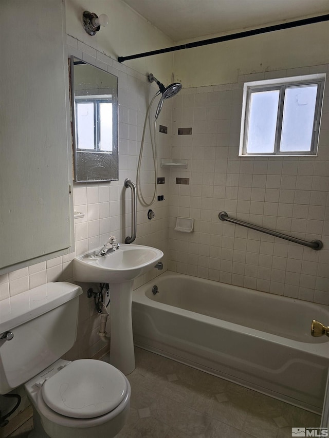 bathroom featuring tile patterned floors, toilet, tile walls, and tiled shower / bath combo