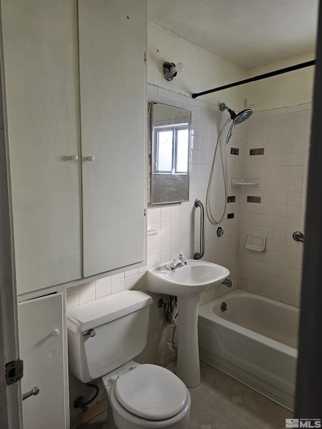 bathroom featuring toilet, tile walls, tiled shower / bath, and backsplash