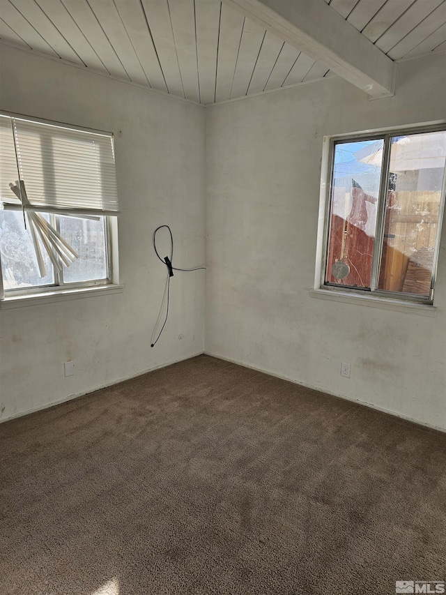 unfurnished room with wooden ceiling, a healthy amount of sunlight, and beamed ceiling
