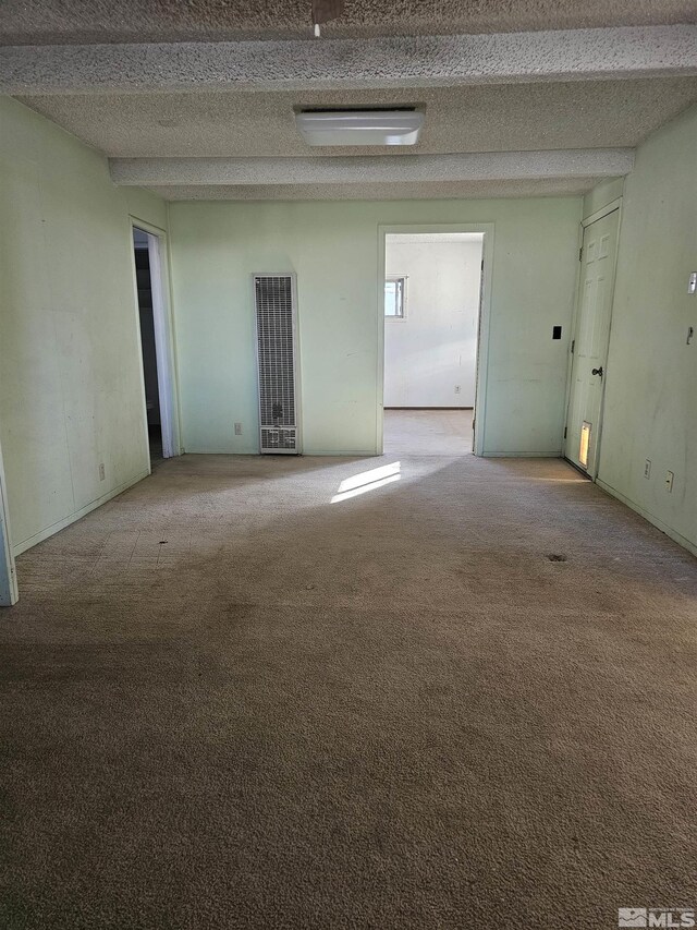 empty room featuring light colored carpet and beam ceiling