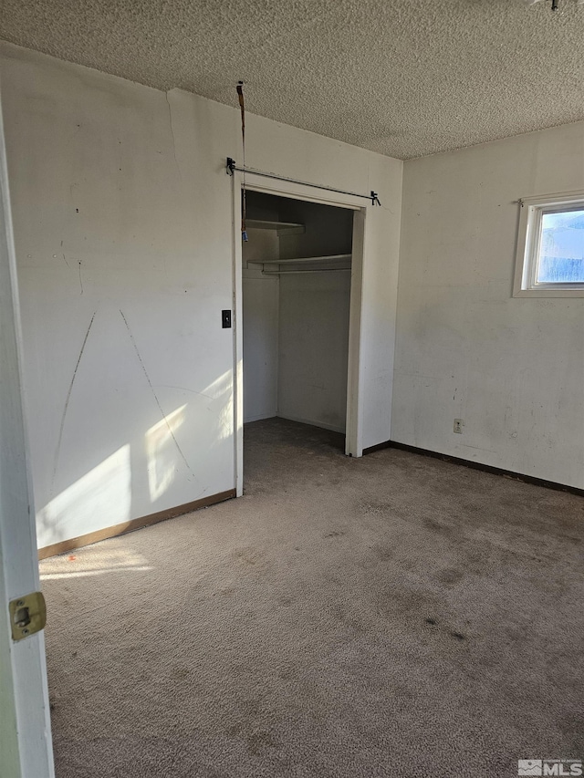 unfurnished bedroom with a textured ceiling and carpet
