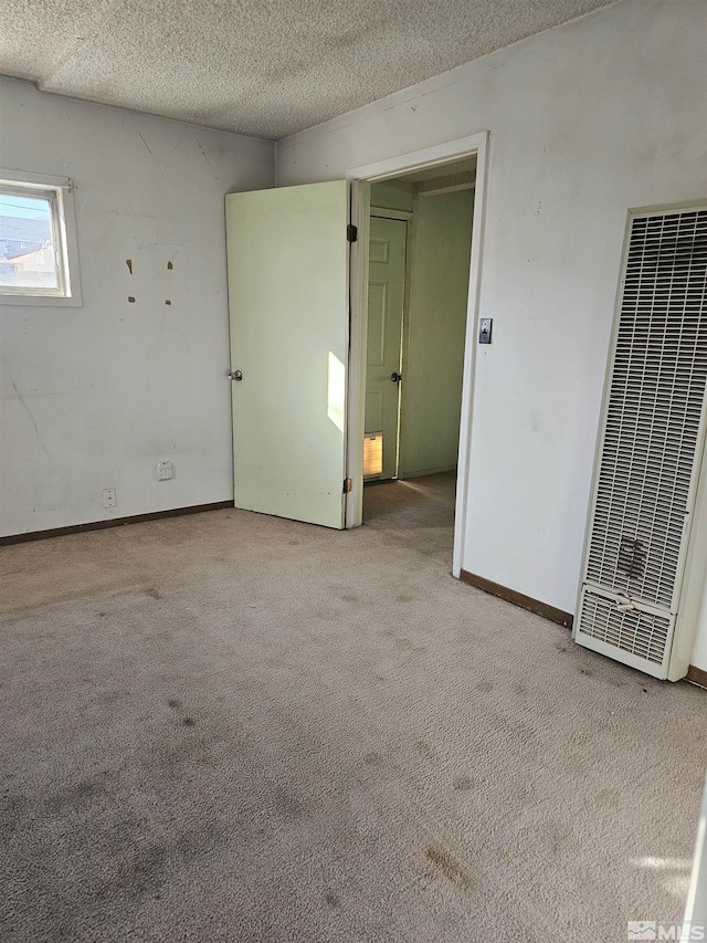 spare room with light colored carpet and a textured ceiling