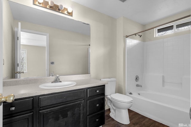 full bathroom with hardwood / wood-style flooring, vanity, bathtub / shower combination, and toilet