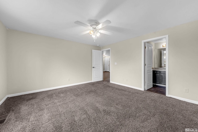 unfurnished bedroom with dark carpet, ceiling fan, and ensuite bathroom