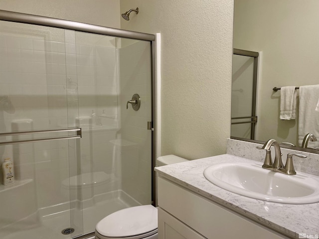 bathroom with toilet, walk in shower, and vanity