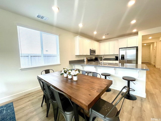 dining room with sink and light hardwood / wood-style flooring