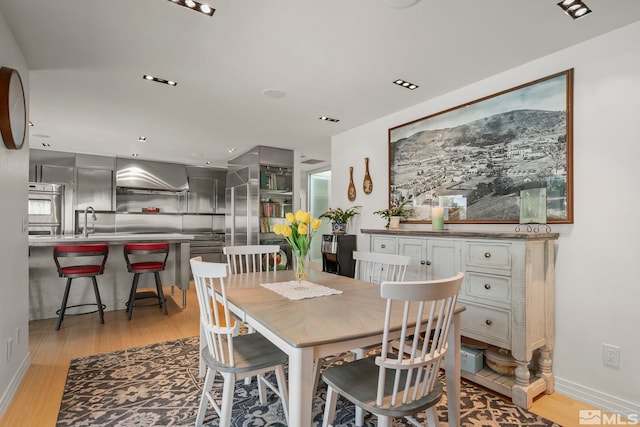 dining room featuring sink and light hardwood / wood-style floors