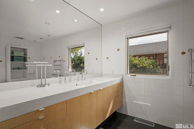 bathroom with vanity, walk in shower, tile patterned floors, and tile walls