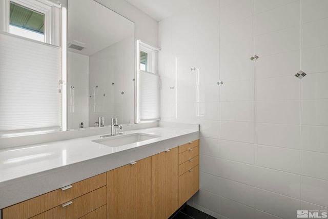 bathroom featuring tile walls and vanity