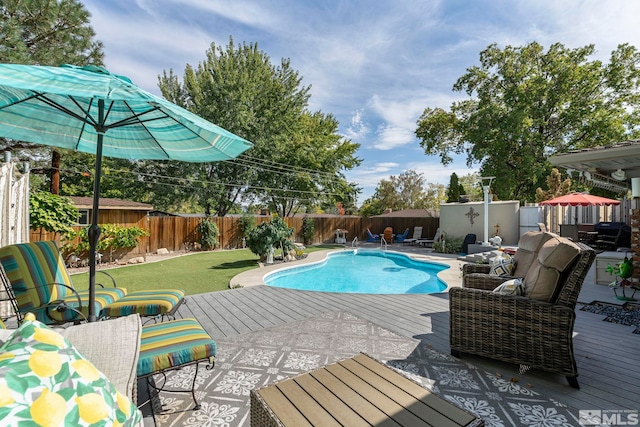 view of pool with a wooden deck, a yard, and an outdoor hangout area