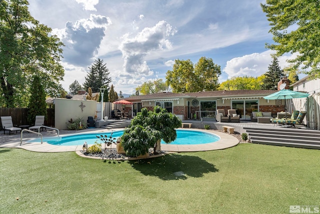 view of swimming pool featuring a lawn, outdoor lounge area, and a patio