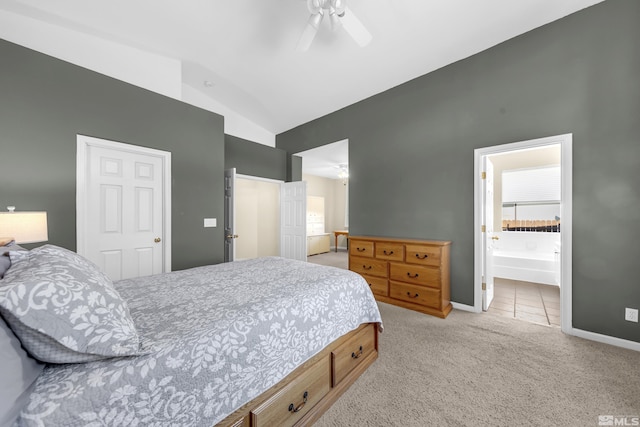 carpeted bedroom with ceiling fan, ensuite bathroom, and vaulted ceiling