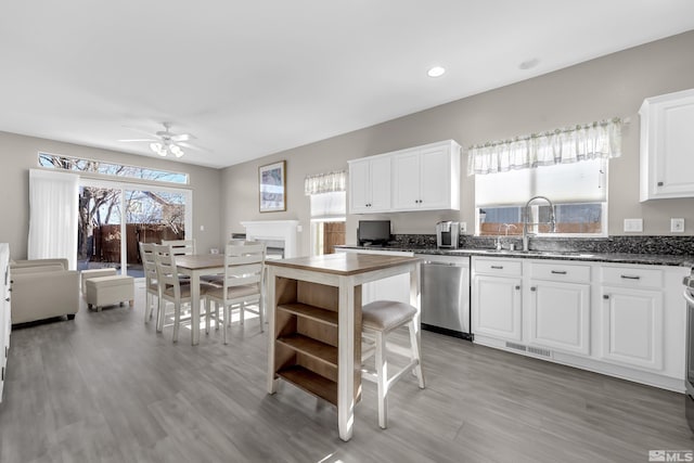 kitchen with sink, white cabinets, dishwasher, and a wealth of natural light