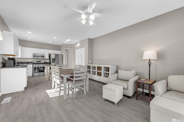 living room with light hardwood / wood-style flooring and ceiling fan