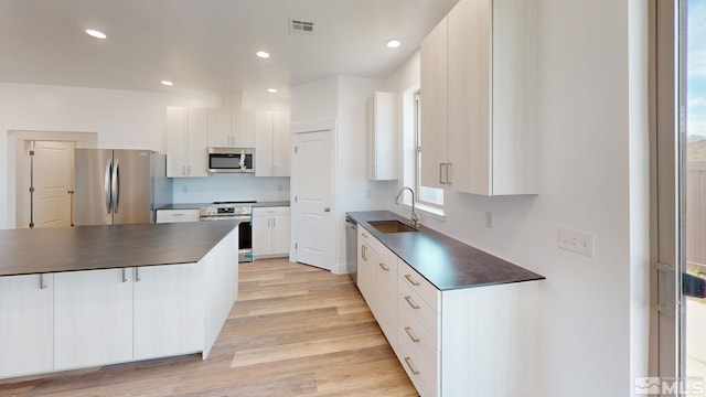 kitchen with white cabinets, appliances with stainless steel finishes, and sink